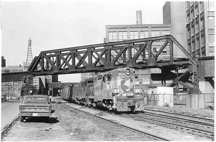 Two diesel locomotives on freight train under truss bridge