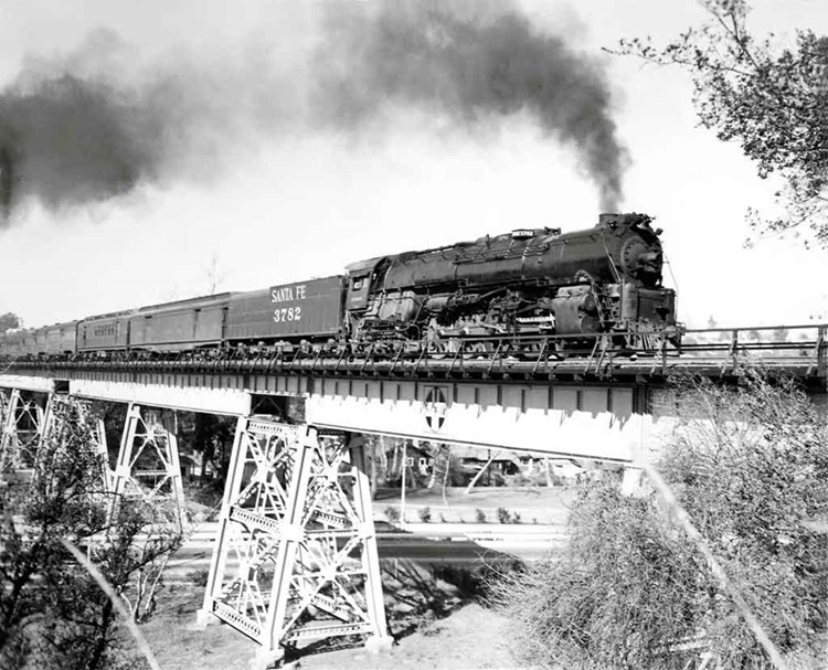 Steam locomotive with passenger train on steel viaduct