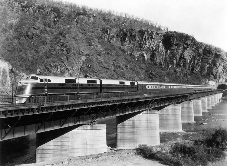 Streamlined diesel passenger train on deck girder bridge
