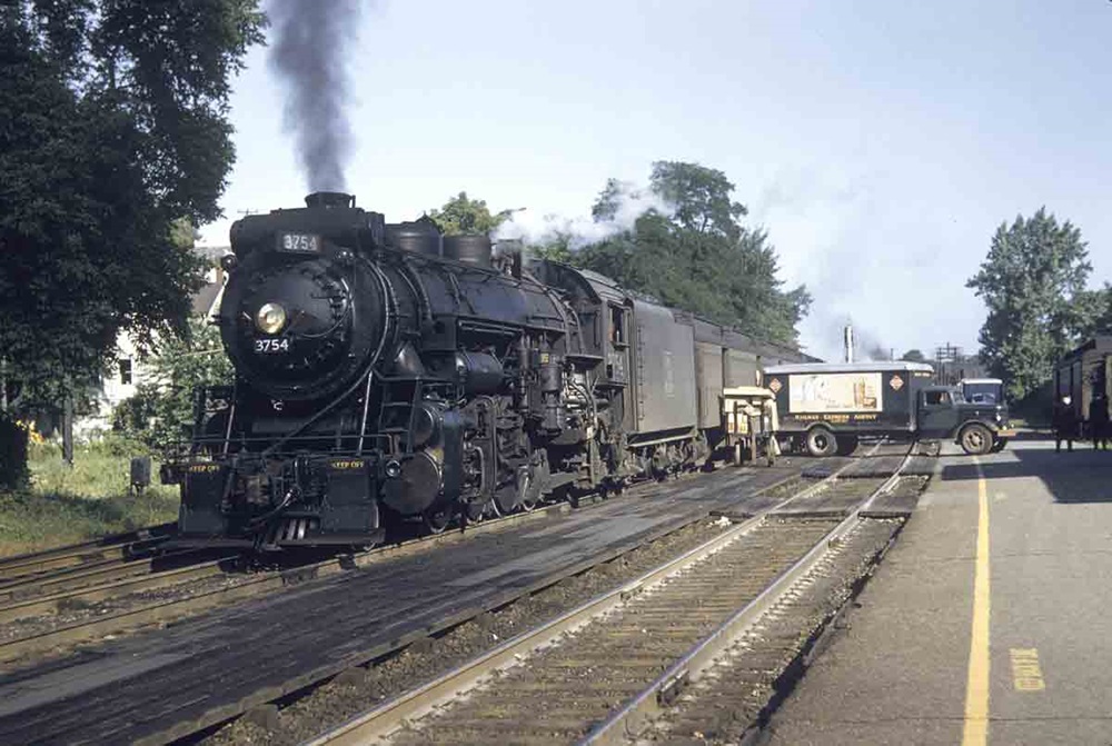 a steam engine pulling passenger cars