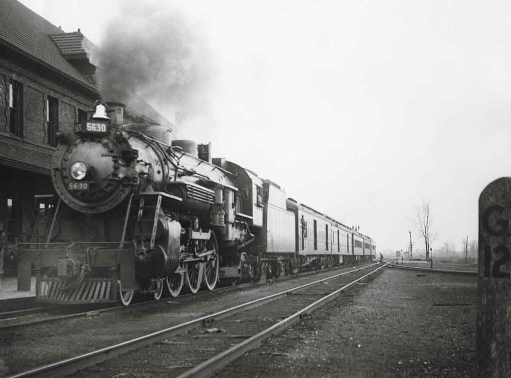 a steam engine pulling passenger cars