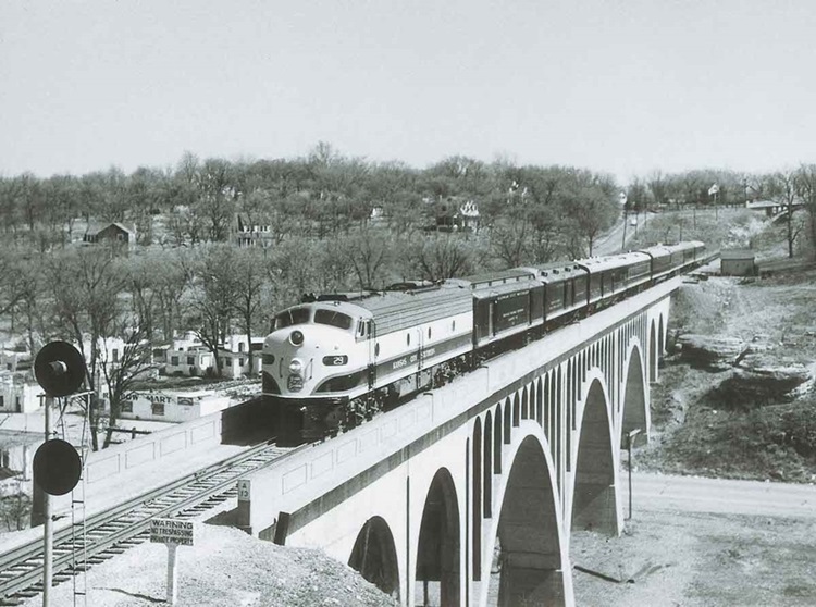 Diesel powered passenger train on concrete arch bridge