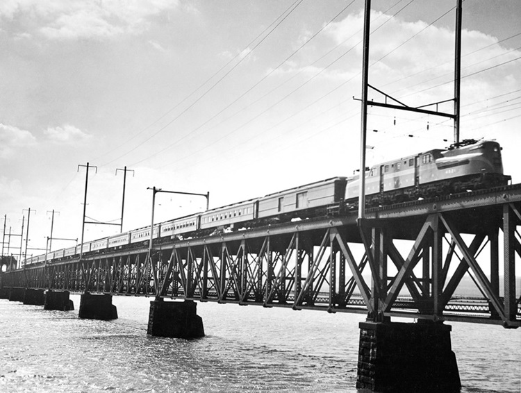 Electric-powered passenger train on deck truss bridge