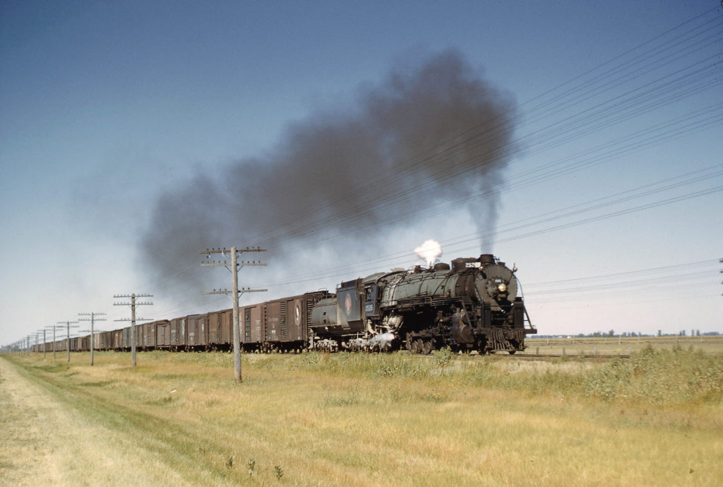 Steam locomotive with boxcars on prairie