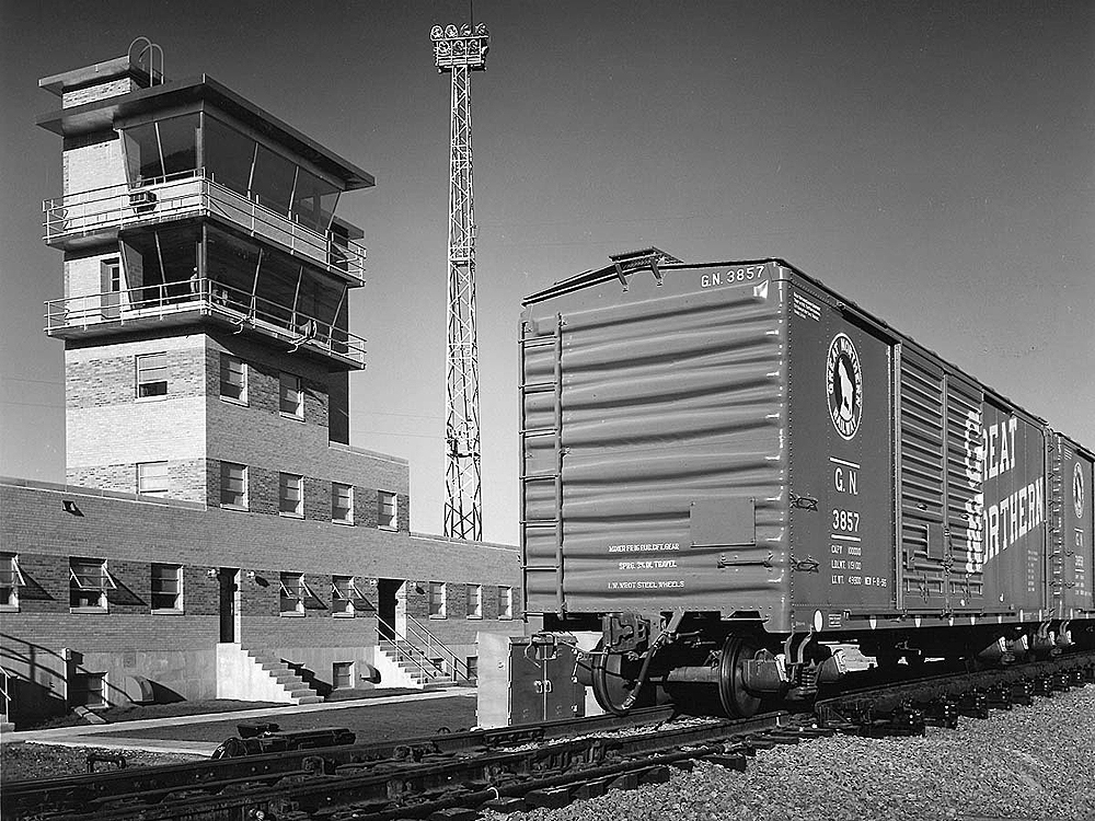 Boxcar in front of modern rail yard office.
