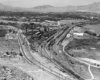 Bird's eye view of a rail yard in a mountain valley town.