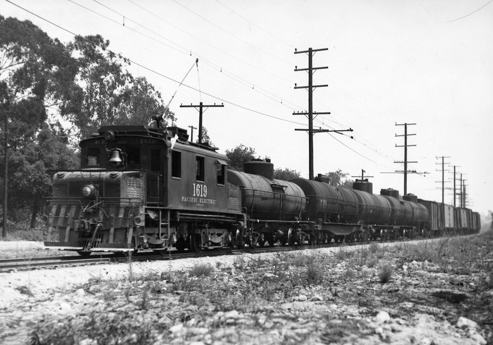 An electric freight motor hauling tank cars.