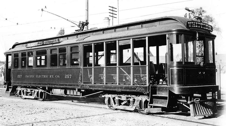 A side-long image of a half-open, half-enclosed electric interurban car.