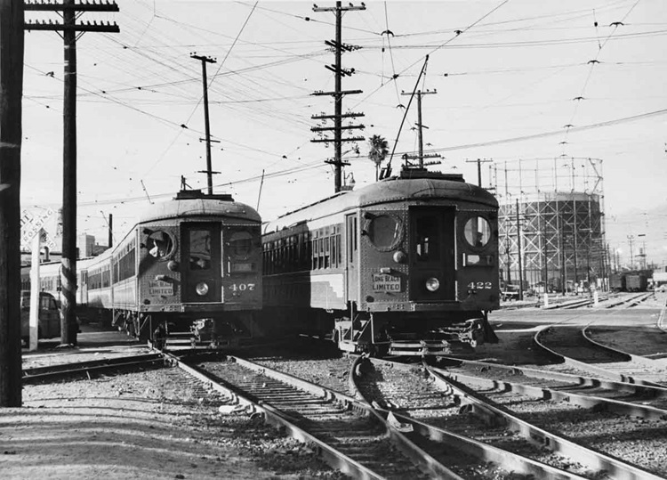 Two electric interurban passenger trains pass each other on complicated track work.
