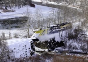 A snow plow going over a bridge