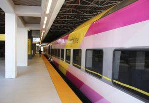 person walking on the platform next to a passenger train