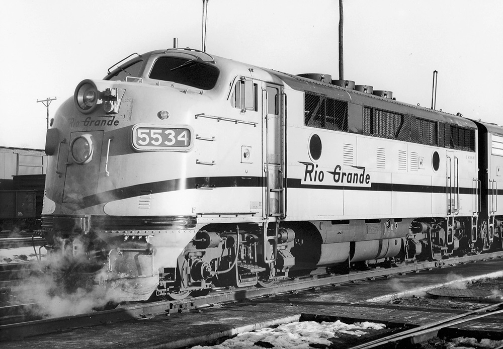 Oblique front view of a cab style diesel locomotive in a rail yard.