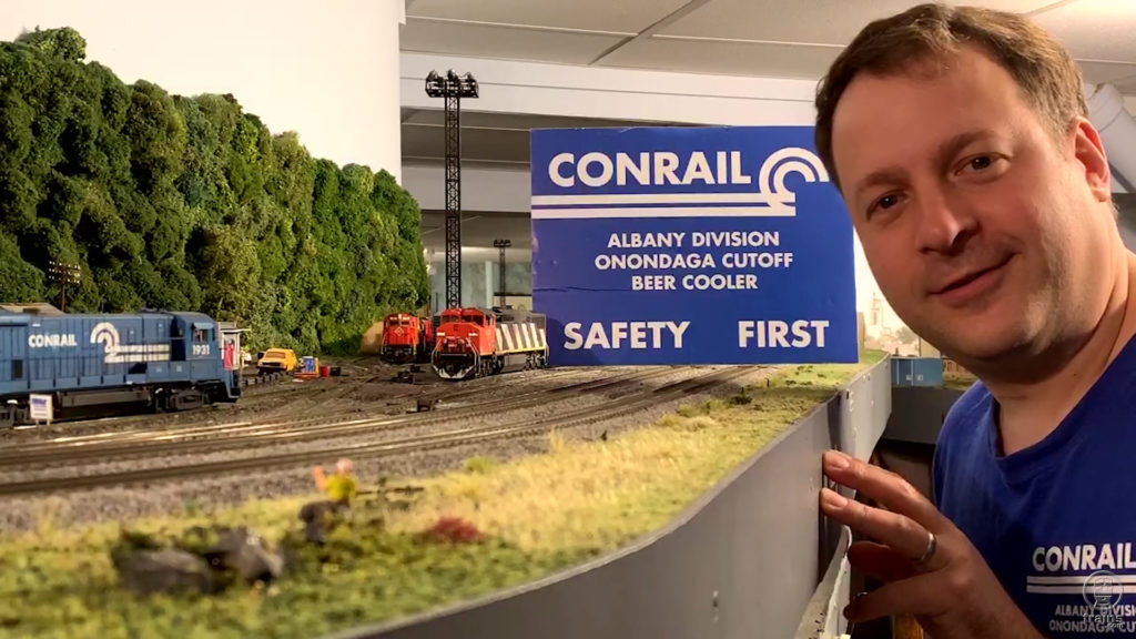 Dave Abeles standing next to his HO scale model railroad