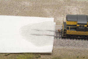 Streaks of dirt and grime on towel wetted with isopropyl alcohol and rear of H-16-44 visible at right of frame.