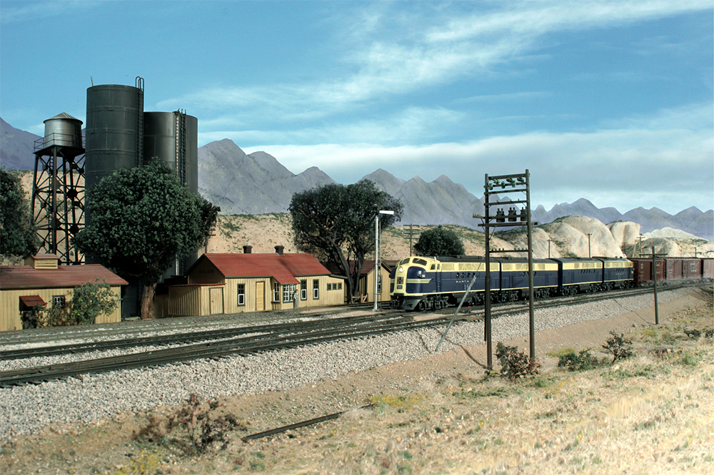 Santa Fe blue-and-yellow freight-painted cab units roll through Gary Hoover's depiction of southern California's arid mountains in this HO Scale model railroad