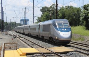 A train riding besides another set of empty tracks