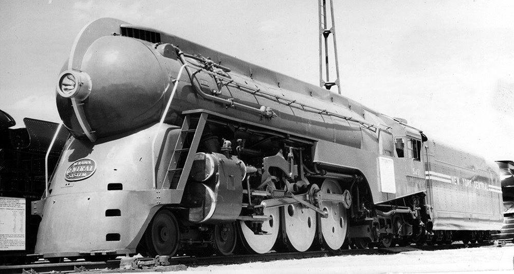 A streamlined steam locomotive paused on a track.