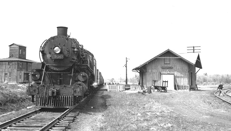 Front of a train pulled up next to a building