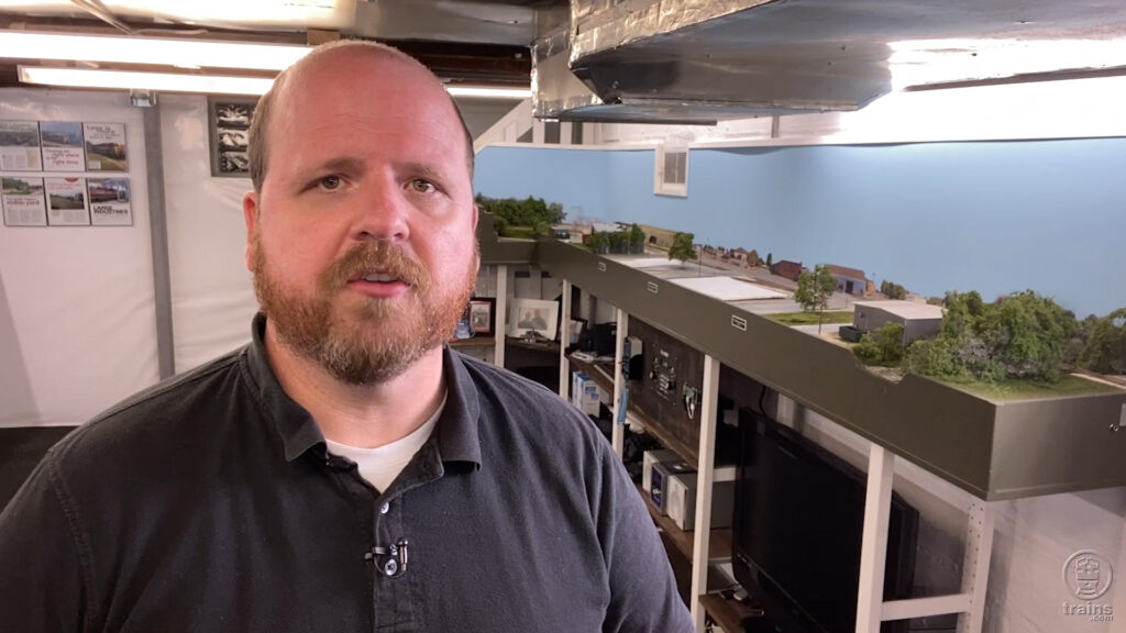 James McNab standing next to his HO scale Hills Line model railroad