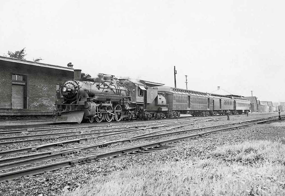 Steam locomotive with short passenger train at station