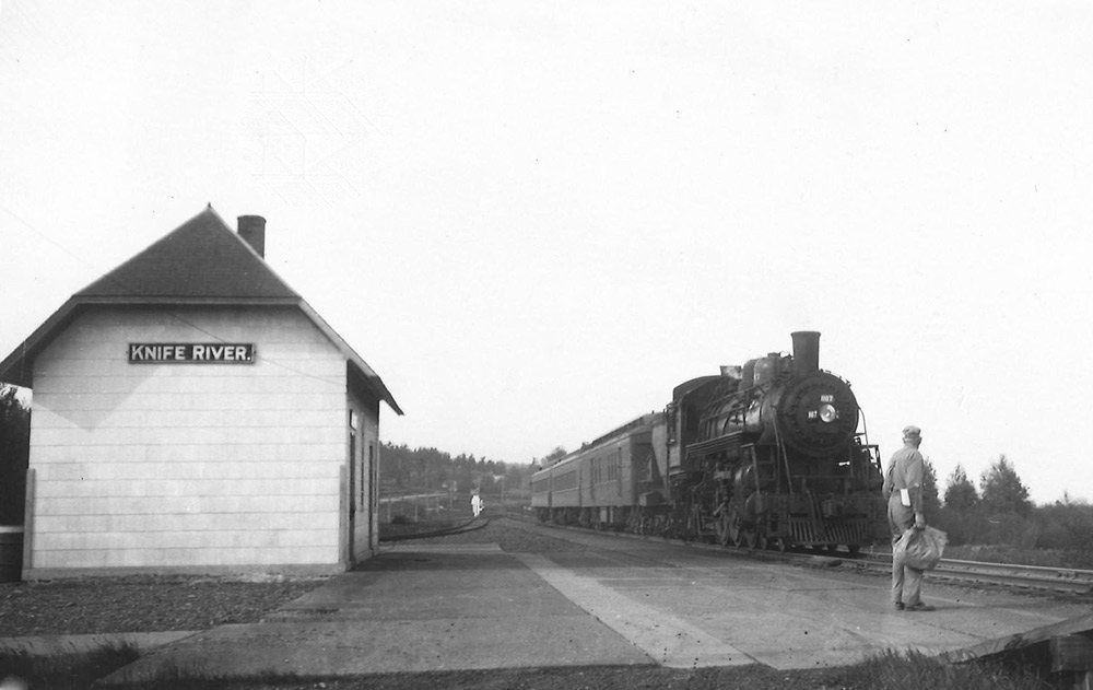 Steam locomotive with short passenger train at station