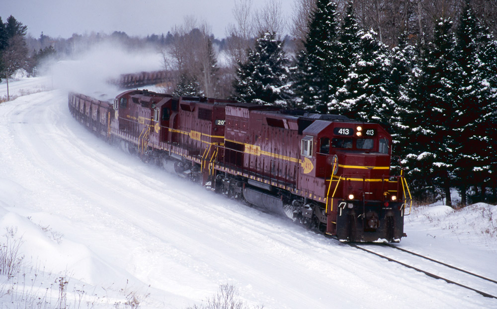 Three road-switcher diesel locomotives with freight train
