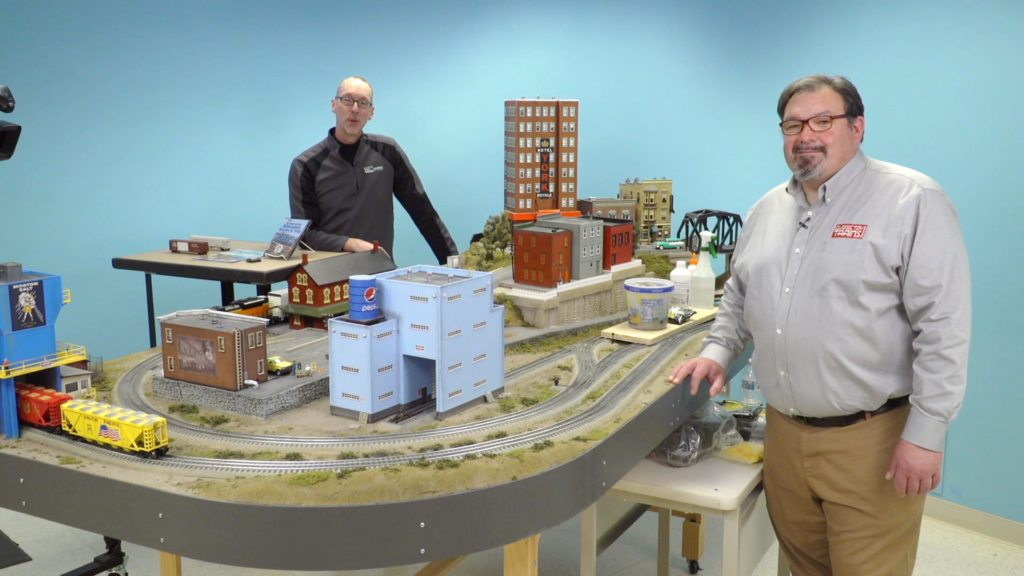 Trains.com staff members Hal Miller and David Popp stand along CTT O gauge layout.