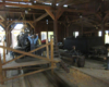 A steam locomotive being worked on is seen through the doorway of a wooden engine shop