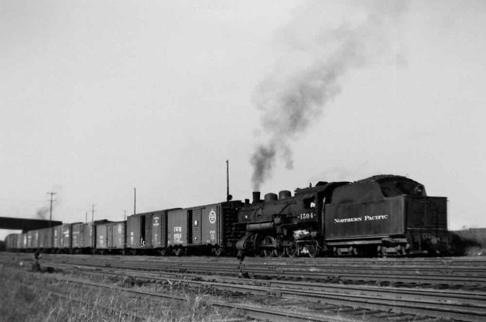 Steam locomotive switching freight cars.