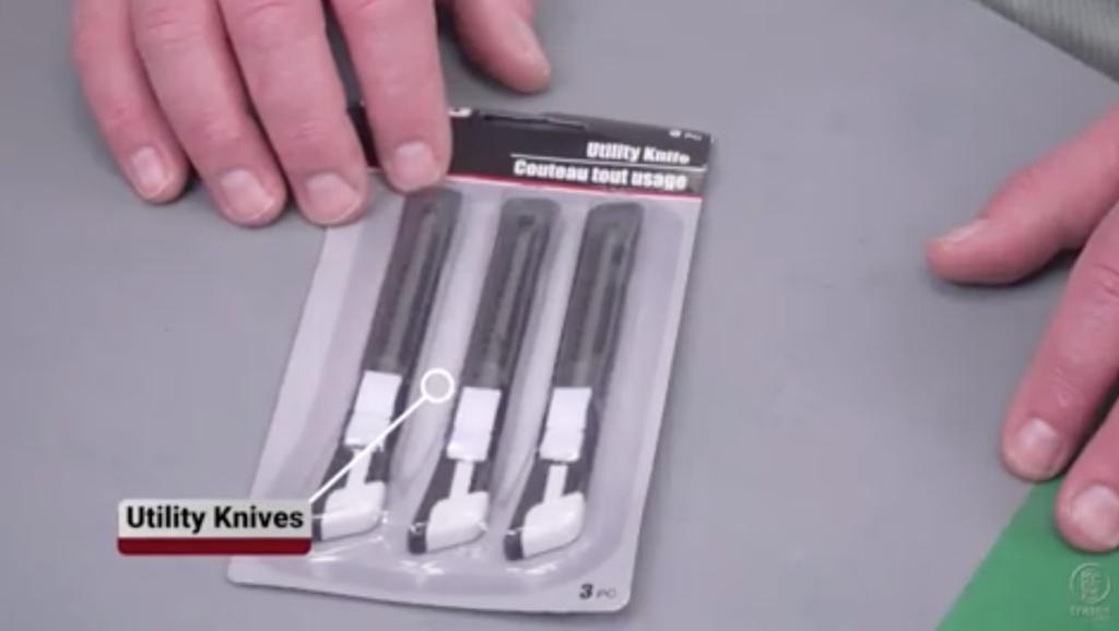 Hand next to a package of utility knives