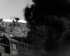 Black smoke follows diesel locomotives exiting tunnel 