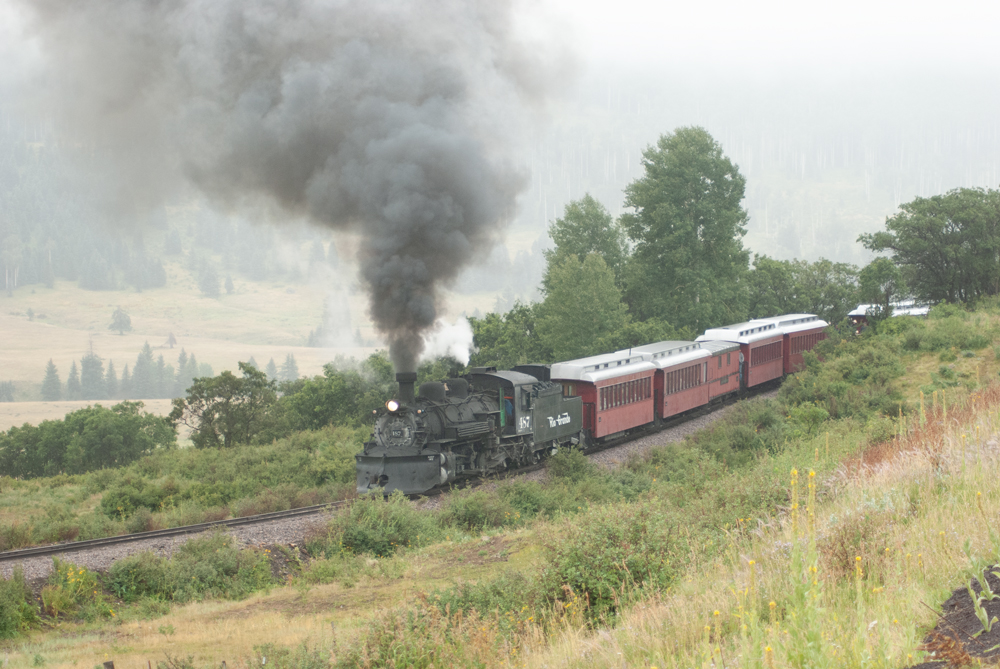 Steam train on hillside.