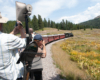 People take pictures in open-air car as train rounds curve