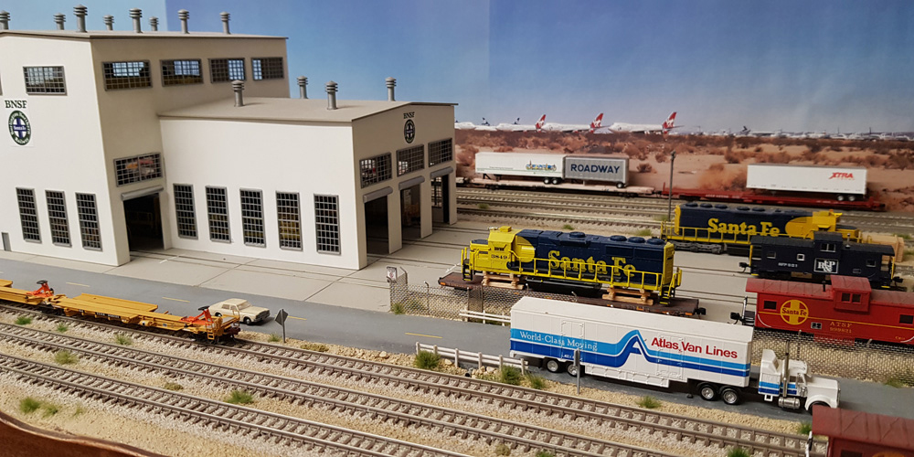 Blue-and-yellow Santa Fe diesel locomotives are serviced at a yard outside a BNSF engine shop