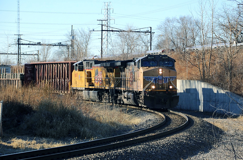 Two yellow diesels bring train downhill on sharp curve