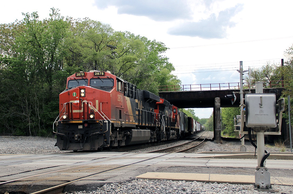 Train with two engines passes under bridge