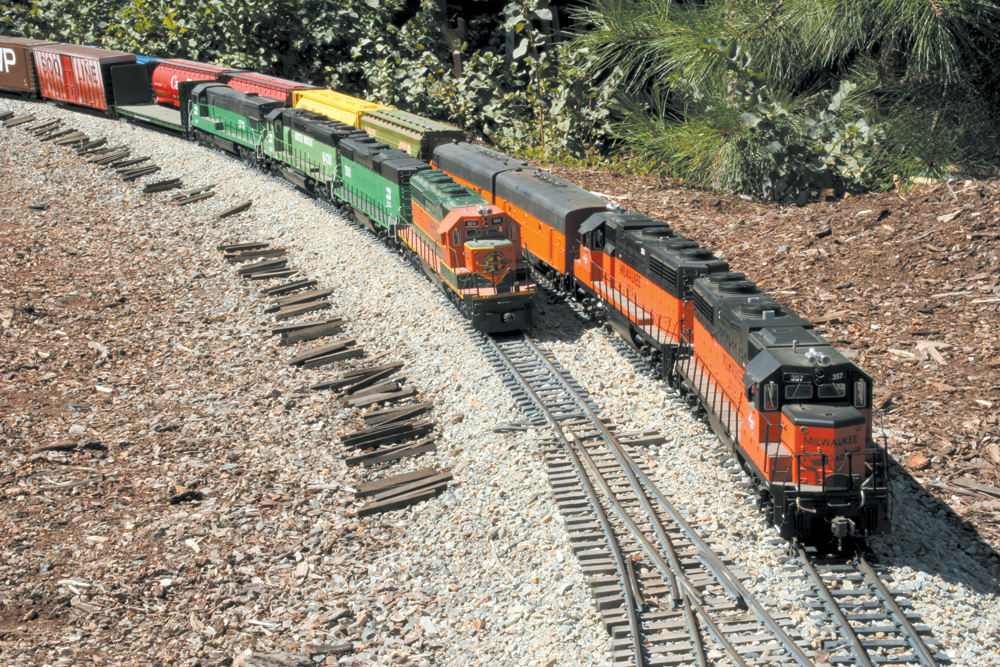 Two model freight trains on a curve