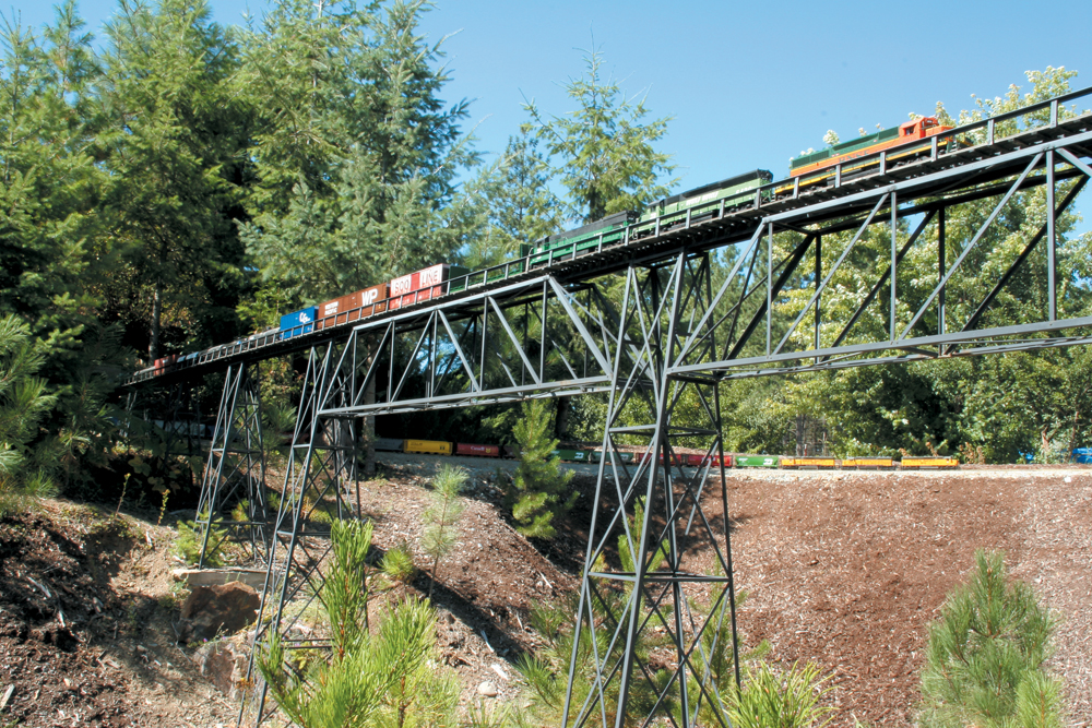 Two model diesels on a high trestle