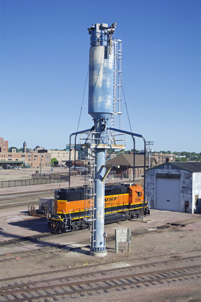Blue two-track sanding tower with BNSF Ry. road locomotive in background.