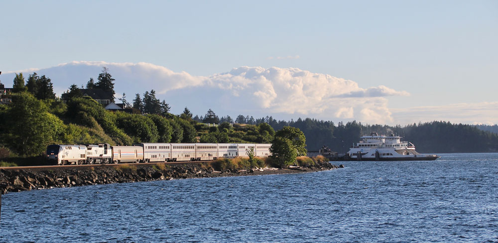 passenger train next to shoreline with ferry