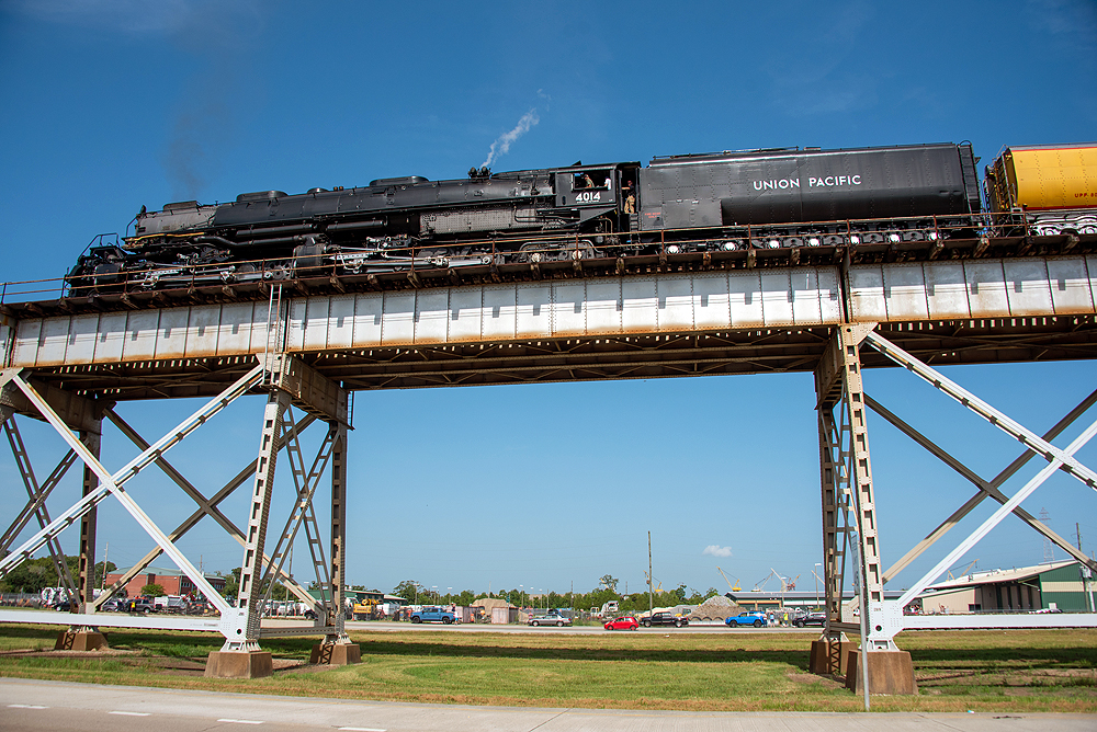 Viewing a large steam locomotive on a bridge from below.
