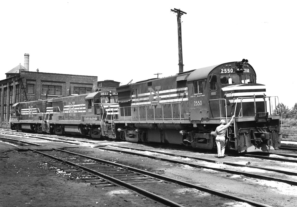 Black-and-white three-quarter view of three diesel road-switcher locomotives coupled together.