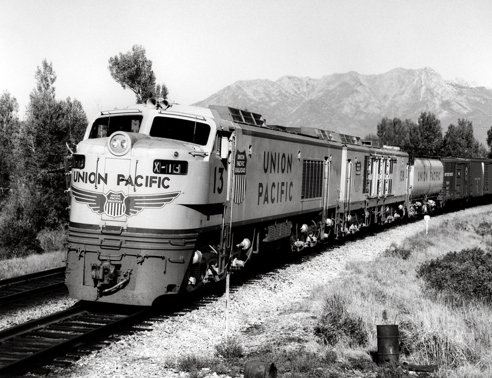Three-quarter-angle black-and-white photo of Union Pacific two-unit gas-turbine electric locomotive on freight train.