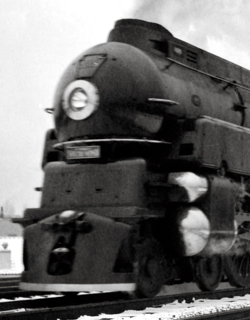 Black-and-white photo of front portion of 4-6-2 steam locomotive.