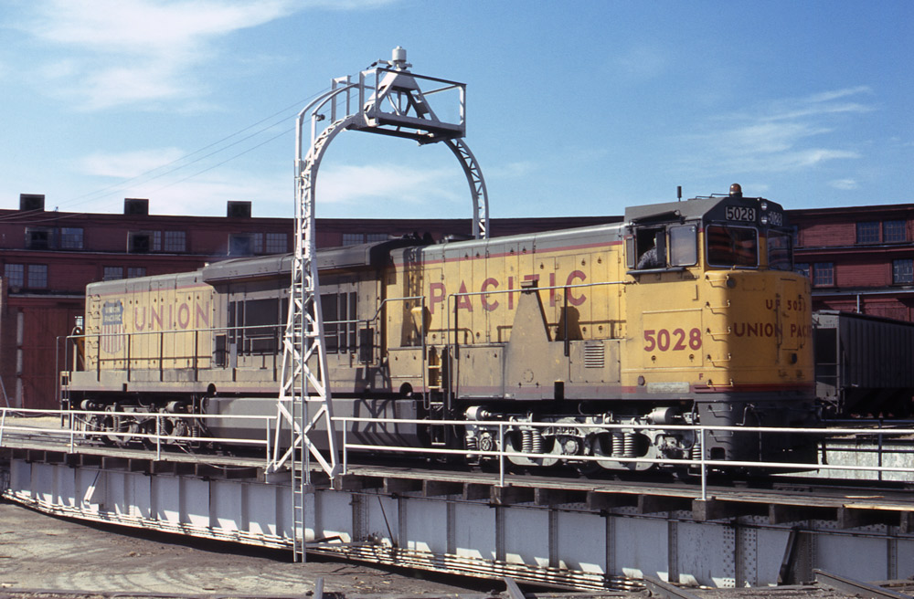Broadside color photo of Union Pacific road-switcher diesel locomotive on turntable.
