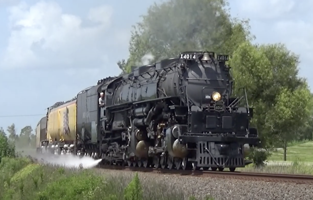 Large steam locomotive pulling a passenger train around a curve. More of the Big Boy story.