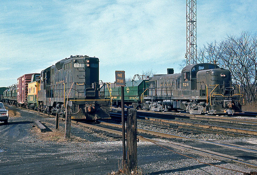 Color photo of two road-switcher diesel locomotives on adjacent tracks