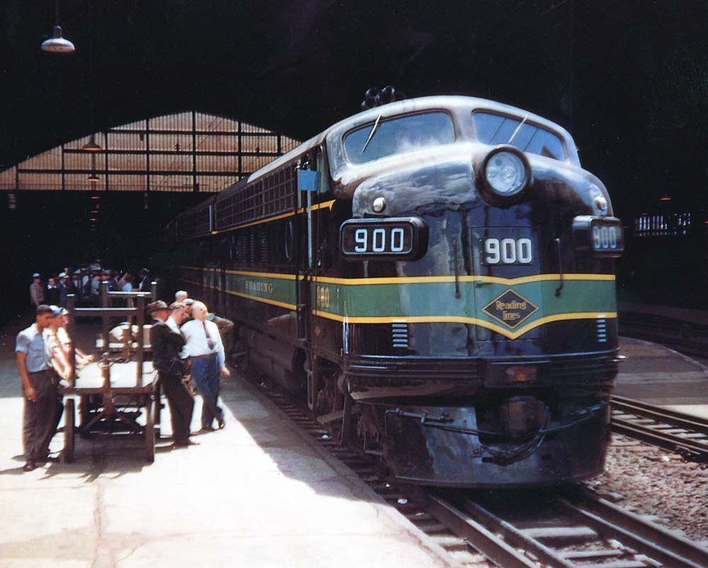 Color photo of streamlined diesel locomotive under arched trainshed