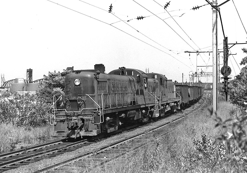 Black-and-white photo of two road-switcher diesel locomotives with Reading Company freight train