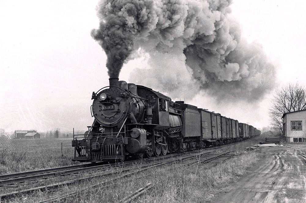 Black-and-white photo of steam locomotive with Reading Company freight train